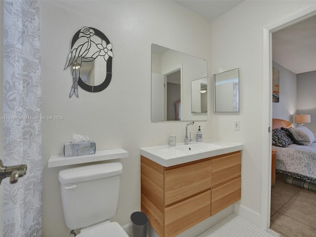 bathroom featuring tile floors, oversized vanity, and toilet