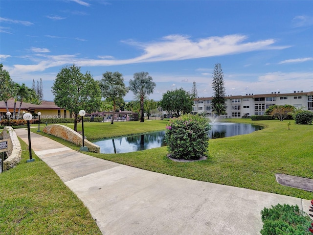 surrounding community with a lawn and a water view