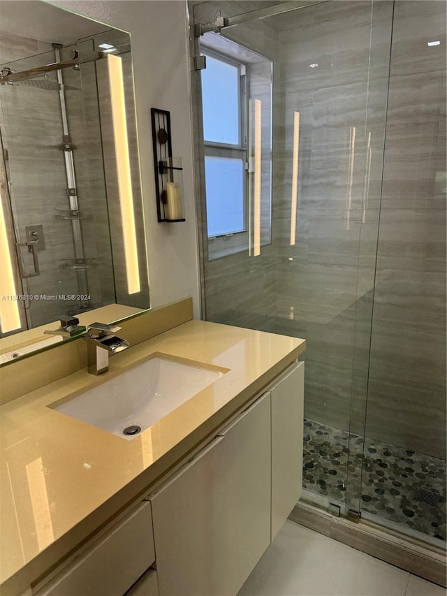 bathroom featuring tile patterned flooring, vanity, and walk in shower