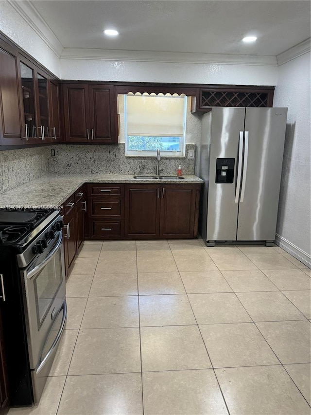 kitchen featuring light stone counters, dark brown cabinets, stainless steel appliances, crown molding, and sink