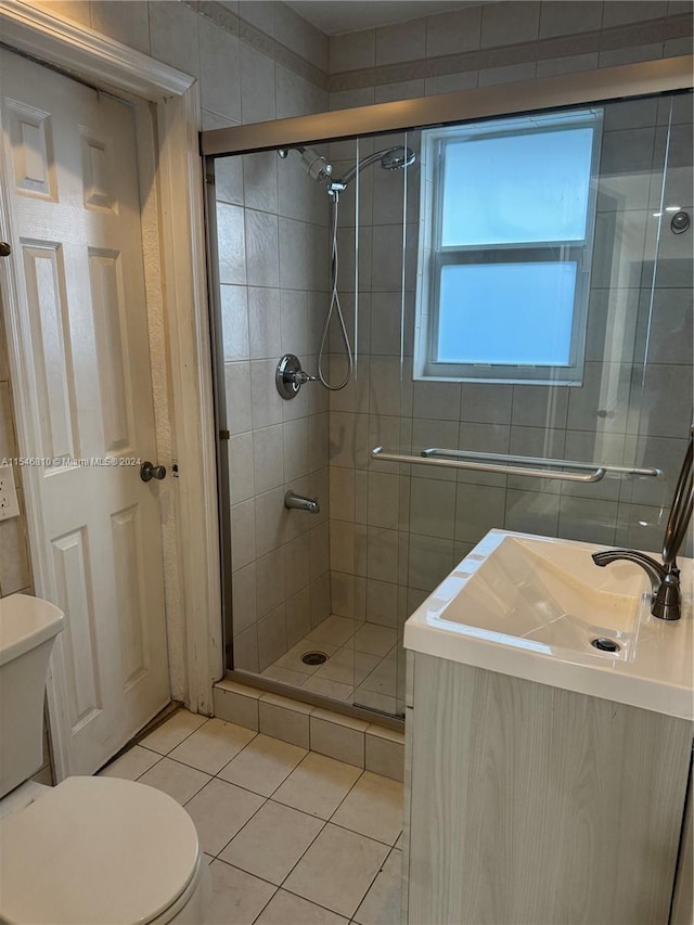 bathroom with tile patterned floors, toilet, sink, and walk in shower