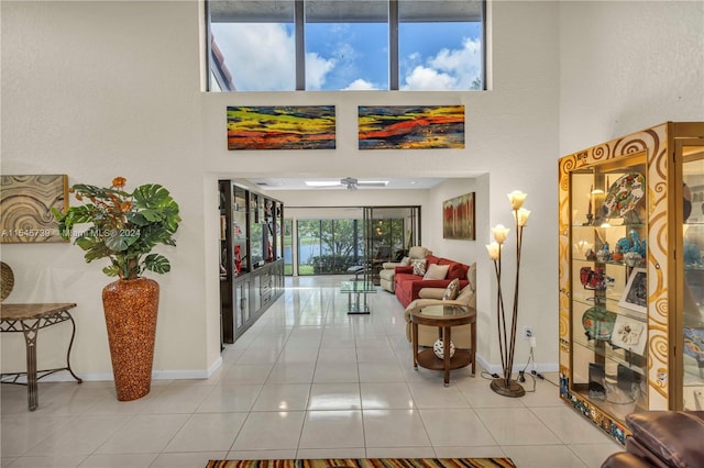 hall with light tile floors and a high ceiling