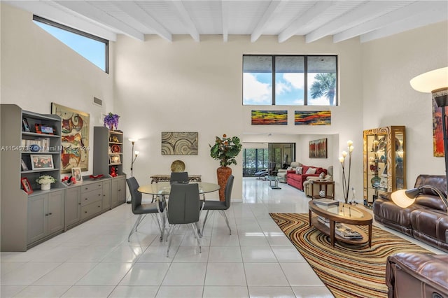 tiled dining room with a towering ceiling and beamed ceiling