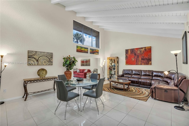 tiled dining area with high vaulted ceiling and beamed ceiling