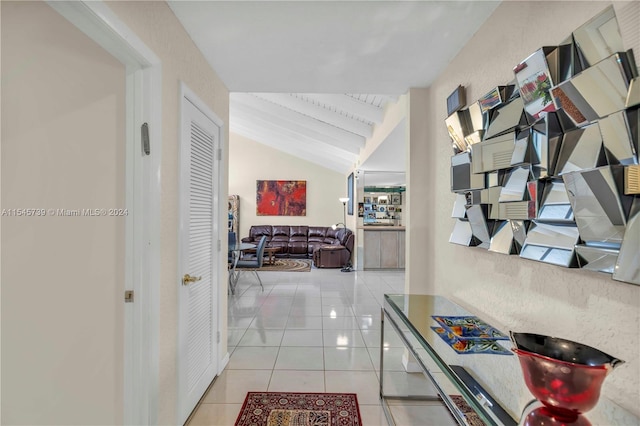 hallway featuring lofted ceiling with beams and light tile floors