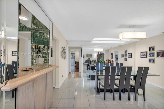 tiled dining space featuring indoor bar