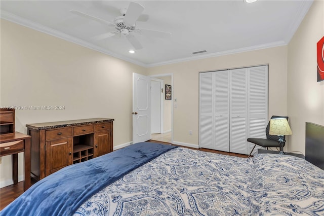 bedroom with a closet, crown molding, ceiling fan, and dark hardwood / wood-style flooring