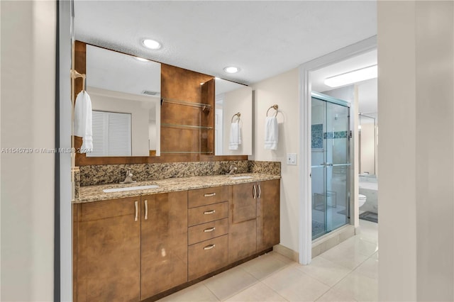 bathroom featuring tile floors, toilet, dual vanity, and an enclosed shower