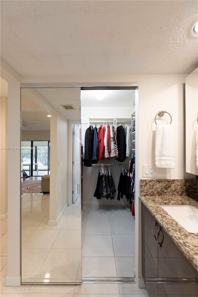 bathroom with vanity, tile flooring, and a textured ceiling