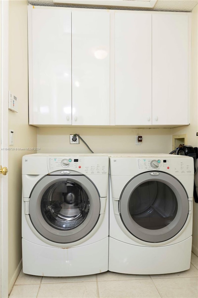 laundry area with electric dryer hookup, light tile flooring, cabinets, hookup for a washing machine, and washer and clothes dryer