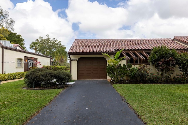 mediterranean / spanish-style home featuring a front lawn and a garage