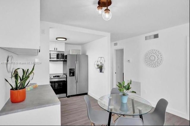 kitchen featuring white cabinetry, light wood-type flooring, and stainless steel appliances