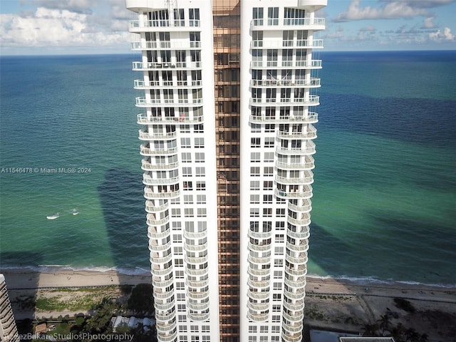 view of building exterior featuring a beach view and a water view