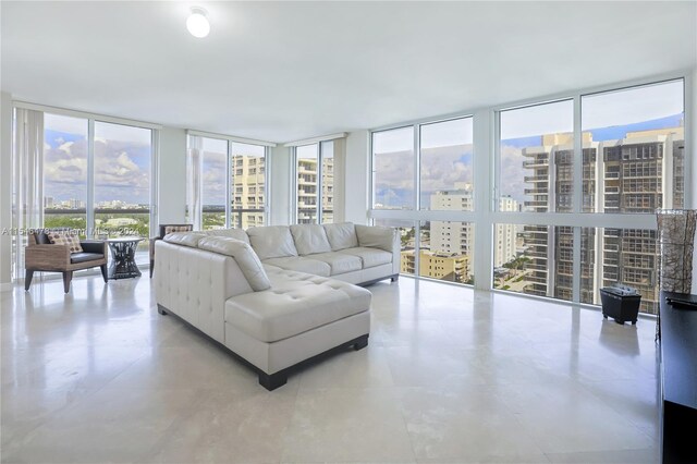 tiled living room featuring floor to ceiling windows