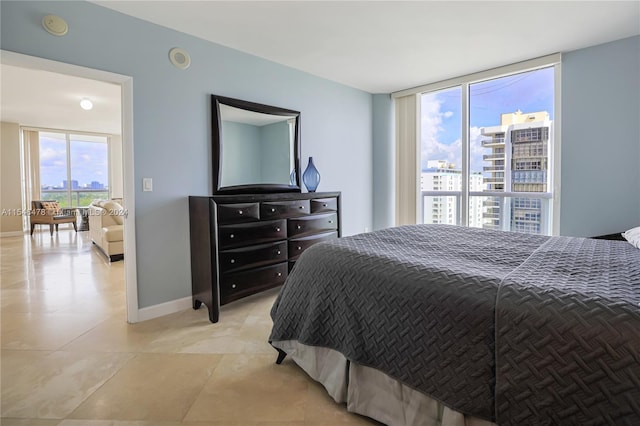 bedroom with light tile floors and floor to ceiling windows