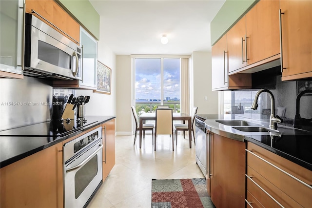 kitchen with sink, appliances with stainless steel finishes, tasteful backsplash, and light tile flooring