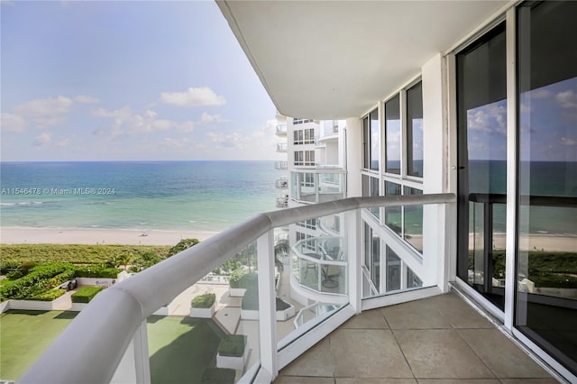 balcony featuring a water view and a view of the beach