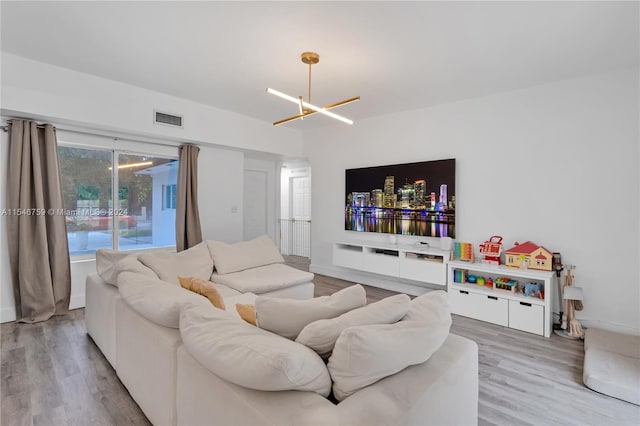 living room with light wood-type flooring and an inviting chandelier