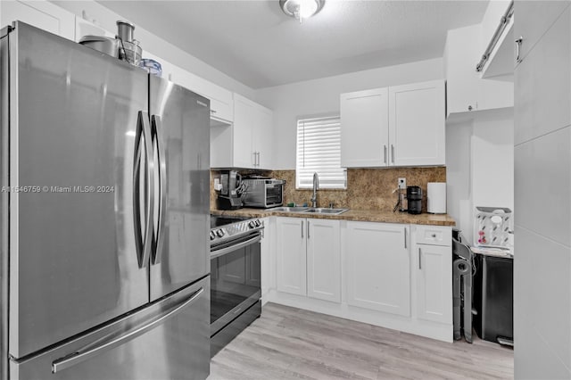 kitchen featuring white cabinets, stainless steel appliances, light hardwood / wood-style flooring, and sink