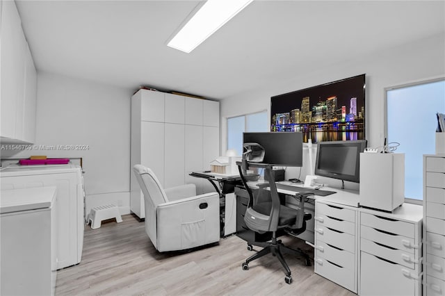 office space featuring a wealth of natural light, independent washer and dryer, and light wood-type flooring