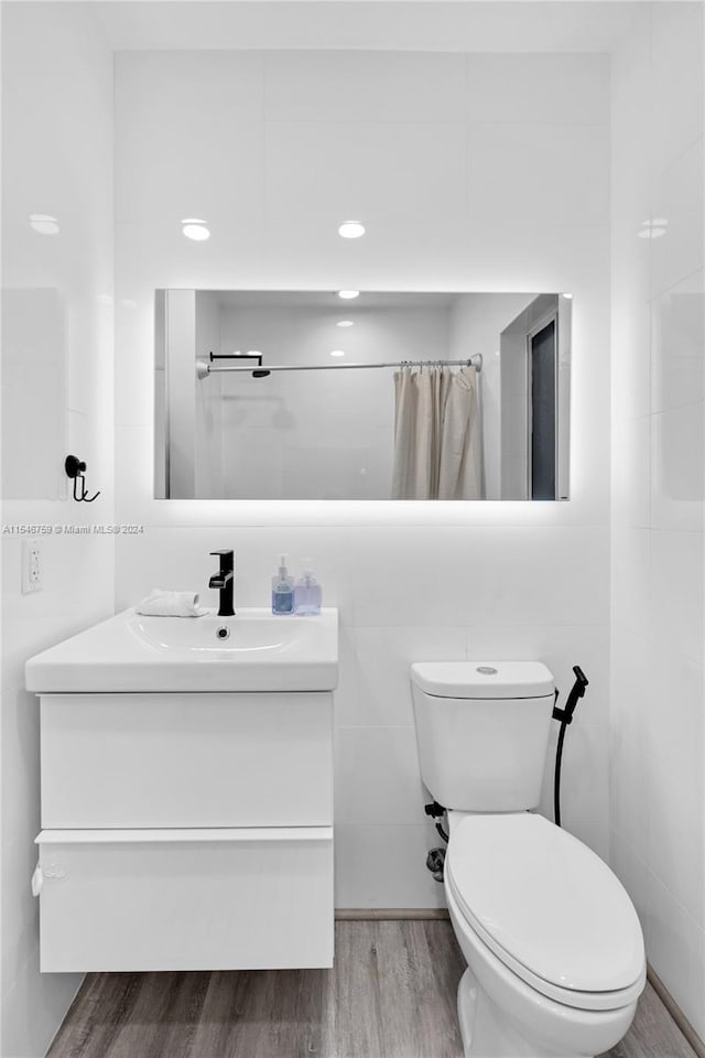 bathroom featuring tile walls, hardwood / wood-style floors, and vanity