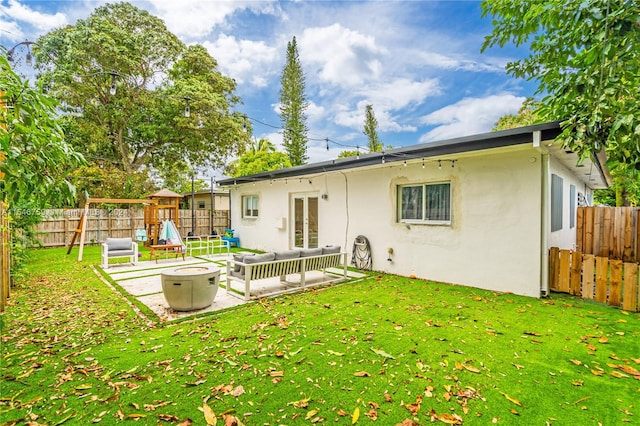 rear view of property with a lawn, a patio area, and a playground