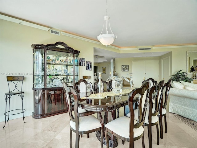 dining room with ornamental molding and light tile floors