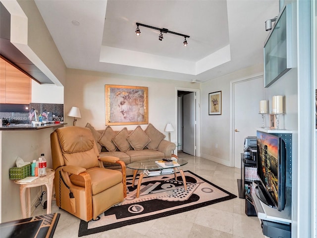 tiled living room with track lighting and a tray ceiling