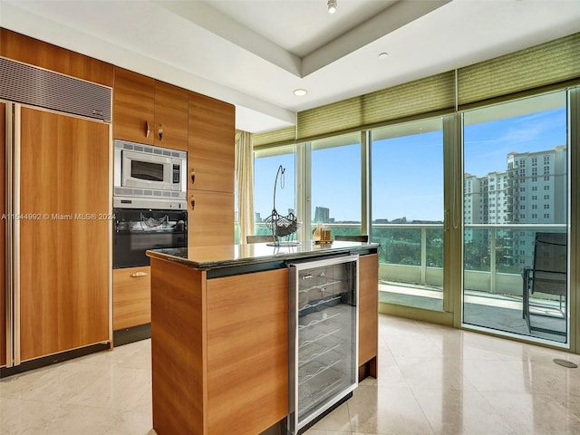 kitchen featuring oven, wine cooler, a center island, light tile floors, and fridge