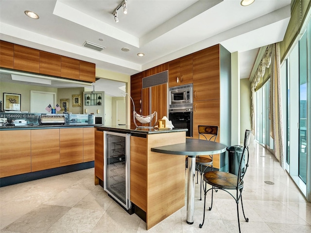 kitchen featuring built in appliances, a kitchen breakfast bar, a center island, light tile flooring, and rail lighting