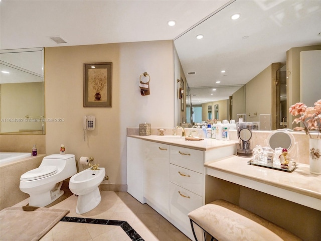 bathroom with tile floors, toilet, a bidet, large vanity, and tiled tub