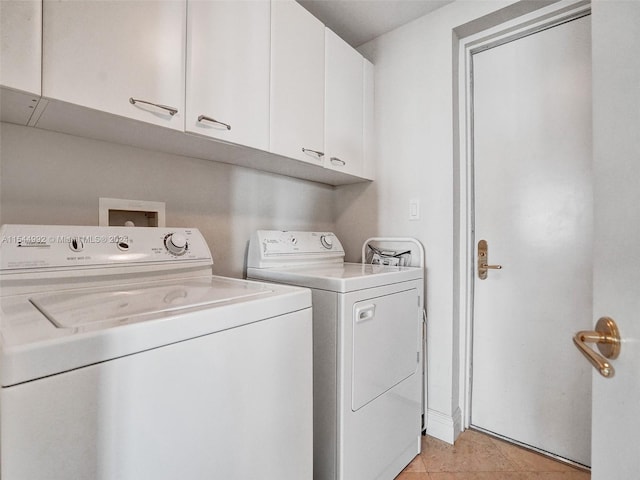 laundry area with independent washer and dryer, light tile floors, and cabinets