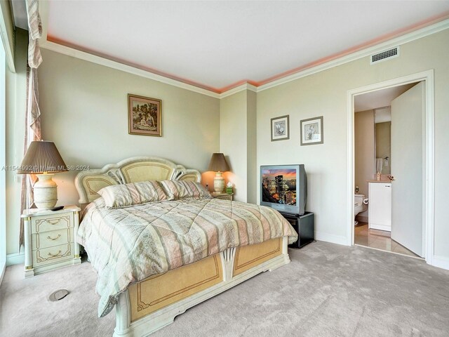 bedroom with ensuite bath, light colored carpet, and ornamental molding