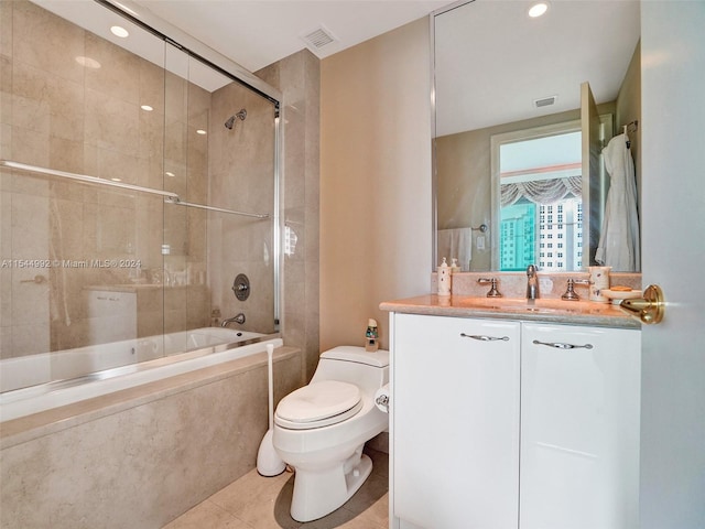 full bathroom with combined bath / shower with glass door, toilet, oversized vanity, and tile flooring