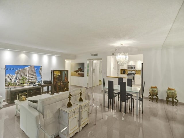 living room featuring light tile floors and a notable chandelier