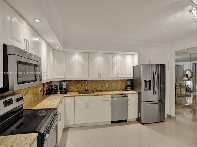 kitchen featuring light stone countertops, white cabinetry, appliances with stainless steel finishes, sink, and light tile floors