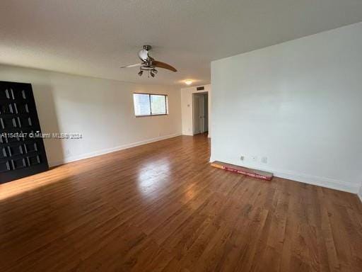 unfurnished room with dark wood-type flooring and ceiling fan