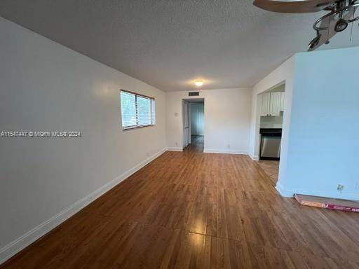 unfurnished living room with a textured ceiling and light hardwood / wood-style flooring