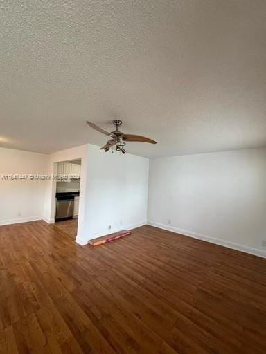 empty room featuring dark hardwood / wood-style flooring, a textured ceiling, and ceiling fan