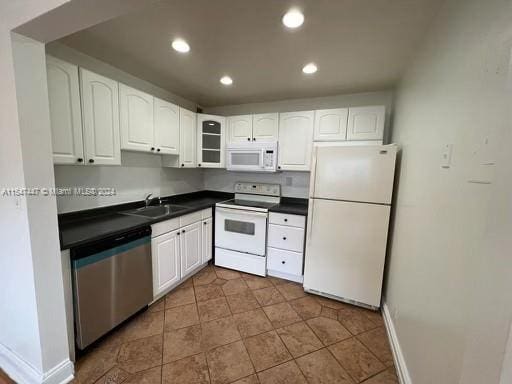 kitchen featuring white cabinets, white appliances, sink, and dark tile flooring