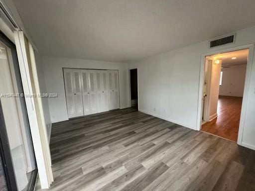 unfurnished bedroom featuring a closet and dark hardwood / wood-style flooring