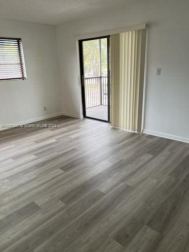 unfurnished room with dark hardwood / wood-style flooring