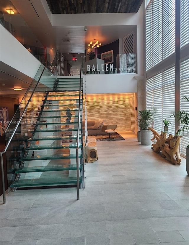 stairway featuring a towering ceiling and light tile flooring