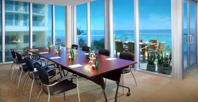 carpeted dining area featuring a water view and plenty of natural light