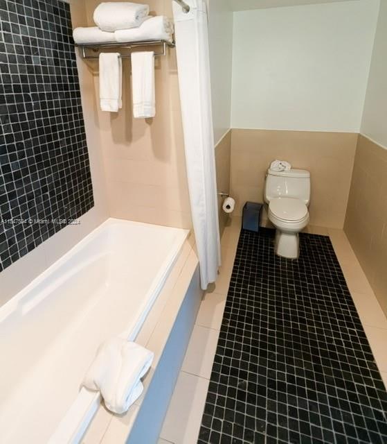 bathroom featuring tile floors and toilet