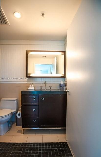 bathroom featuring toilet, tile floors, and vanity