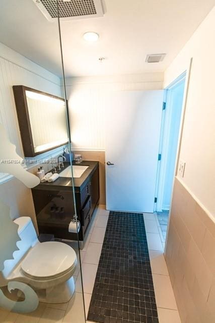 bathroom with toilet, tile floors, and large vanity