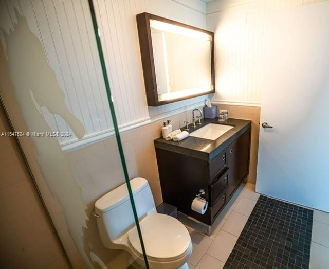 bathroom featuring tile flooring, vanity with extensive cabinet space, and toilet