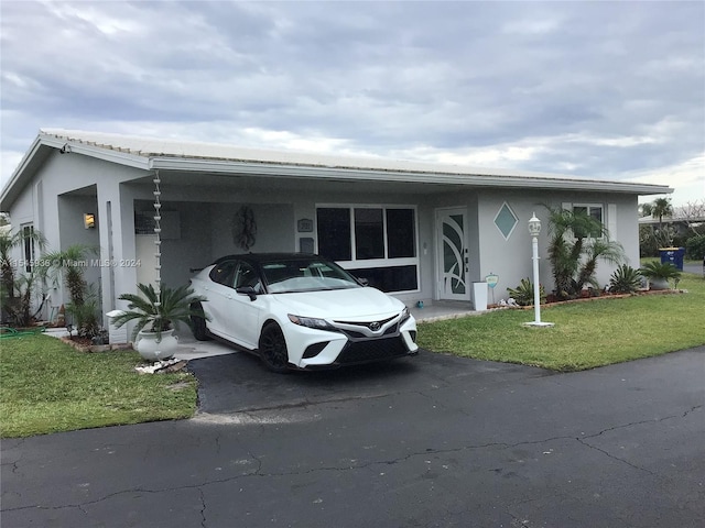 view of front of home featuring a front lawn and a carport