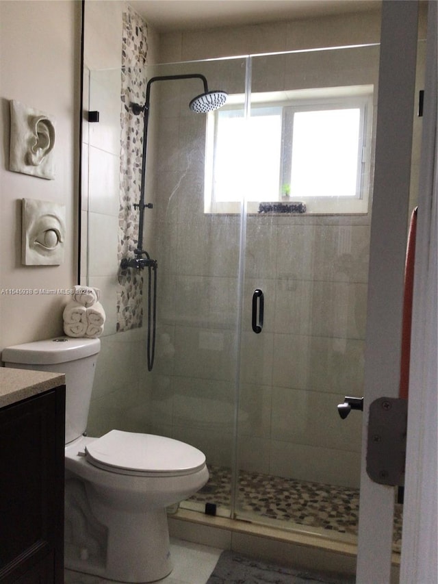 bathroom featuring walk in shower, toilet, and a healthy amount of sunlight